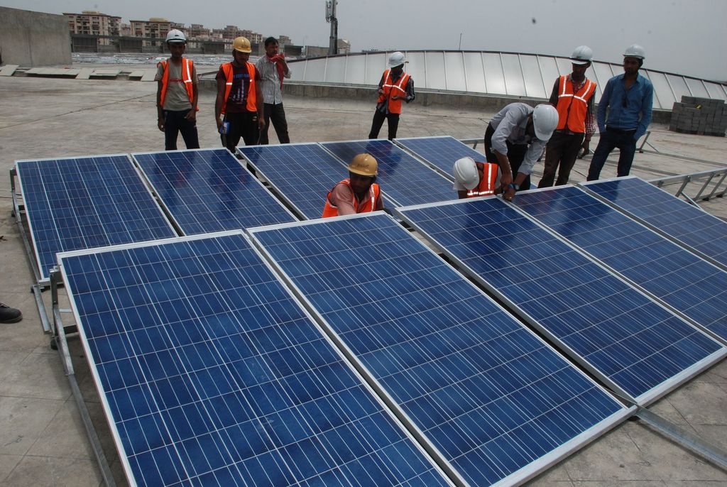Workers in front of solar panels